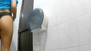 Athletic girl pissing in public bathroom