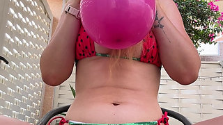 Blowing Balloons Outside in Cute Bikini