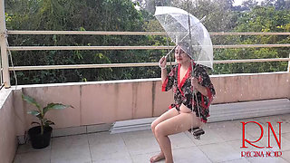 Cute lady is swinging on a hanging swing, hiding from the rain under an umbrella. 185 2